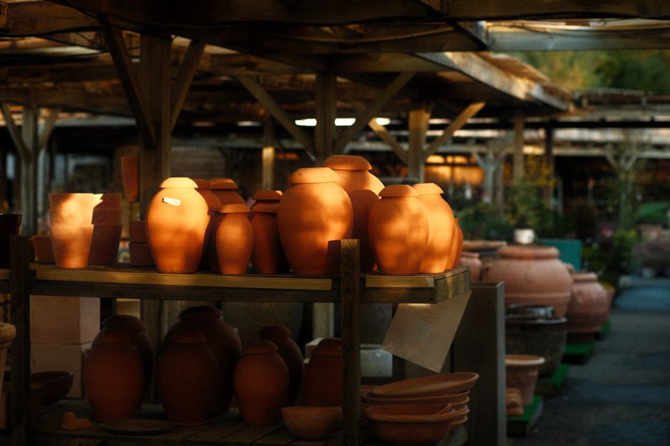 Ember-lit pots glowing on dim shelves